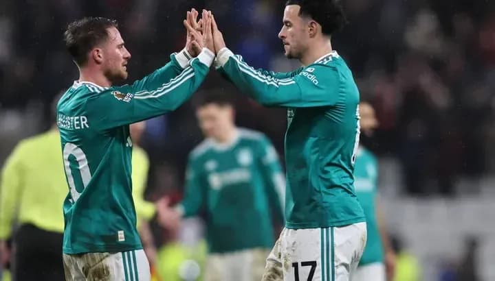 Two players high-fiving on the field after match