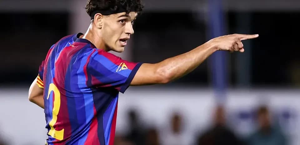 Player in FC Barcelona kit directing teammates during match