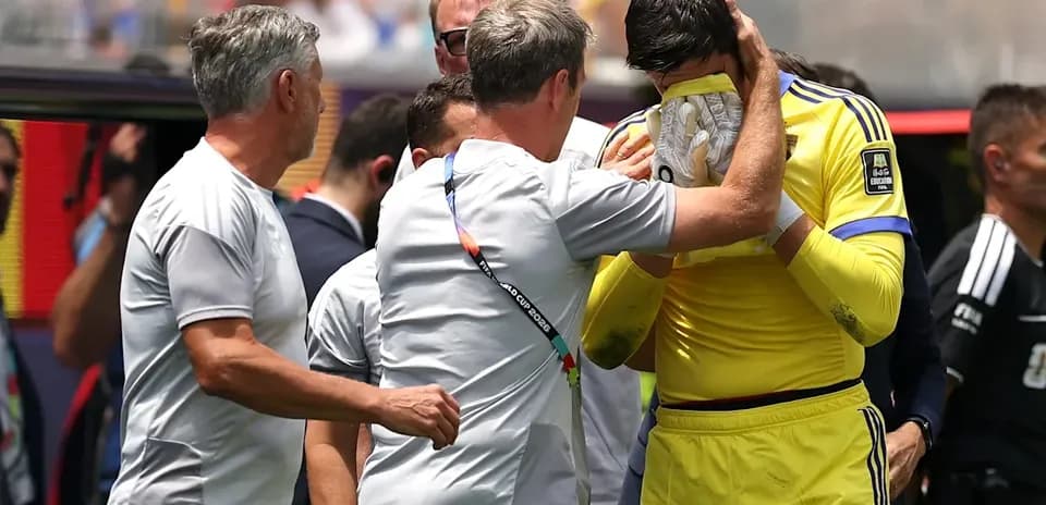 Goalkeeper receiving support from coaching staff during match
