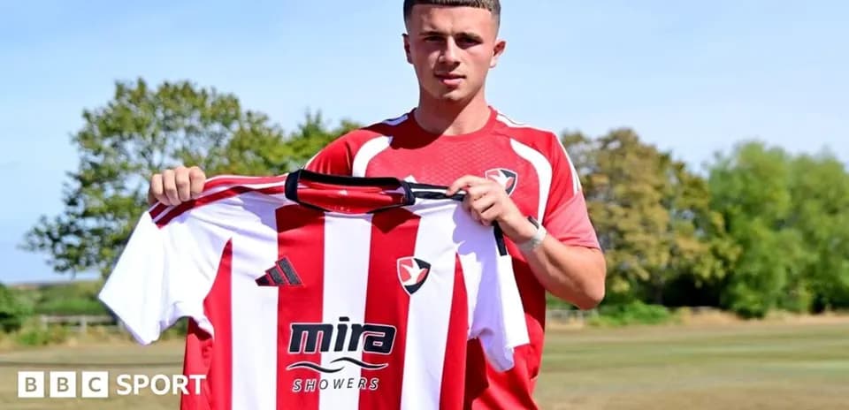 Player holding Cheltenham Town jersey during announcement