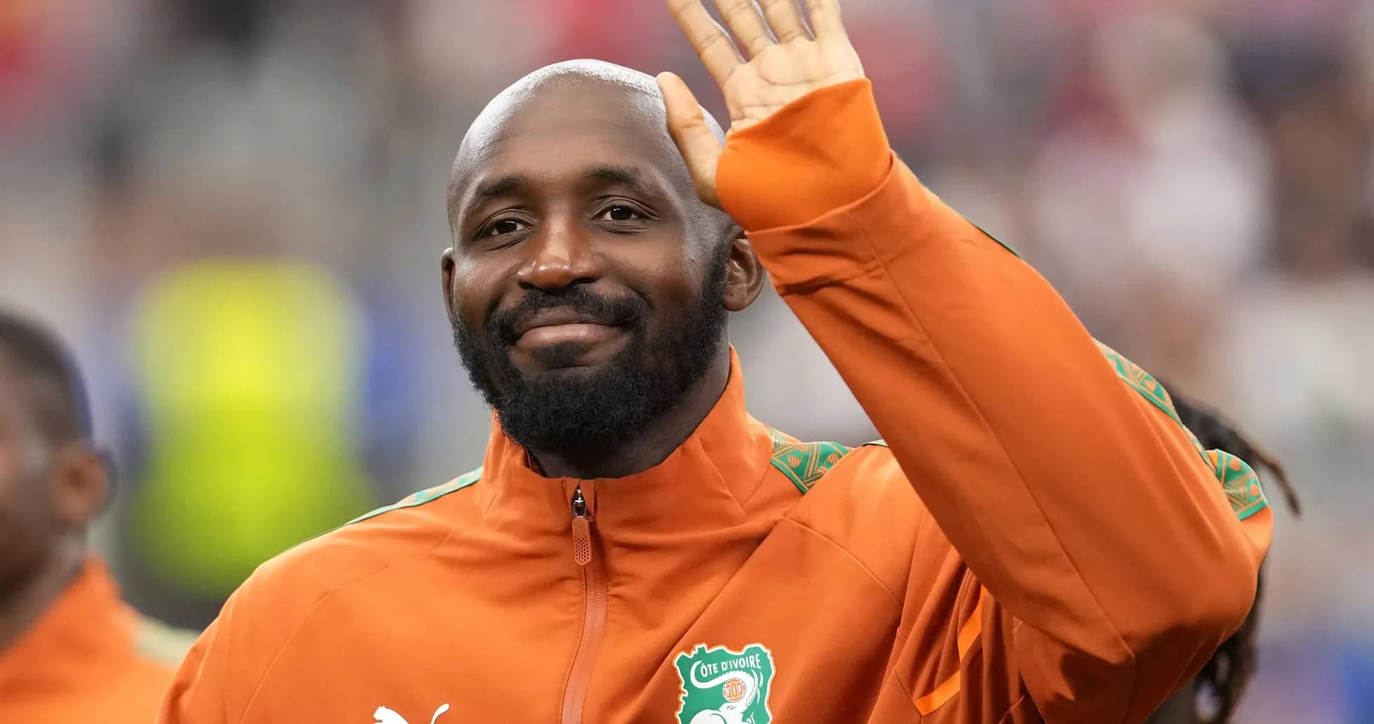 Player waving while wearing Côte d'Ivoire team jacket