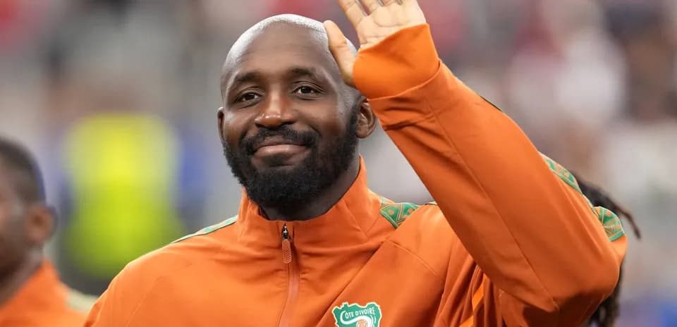 Player waving while wearing Côte d'Ivoire team jacket