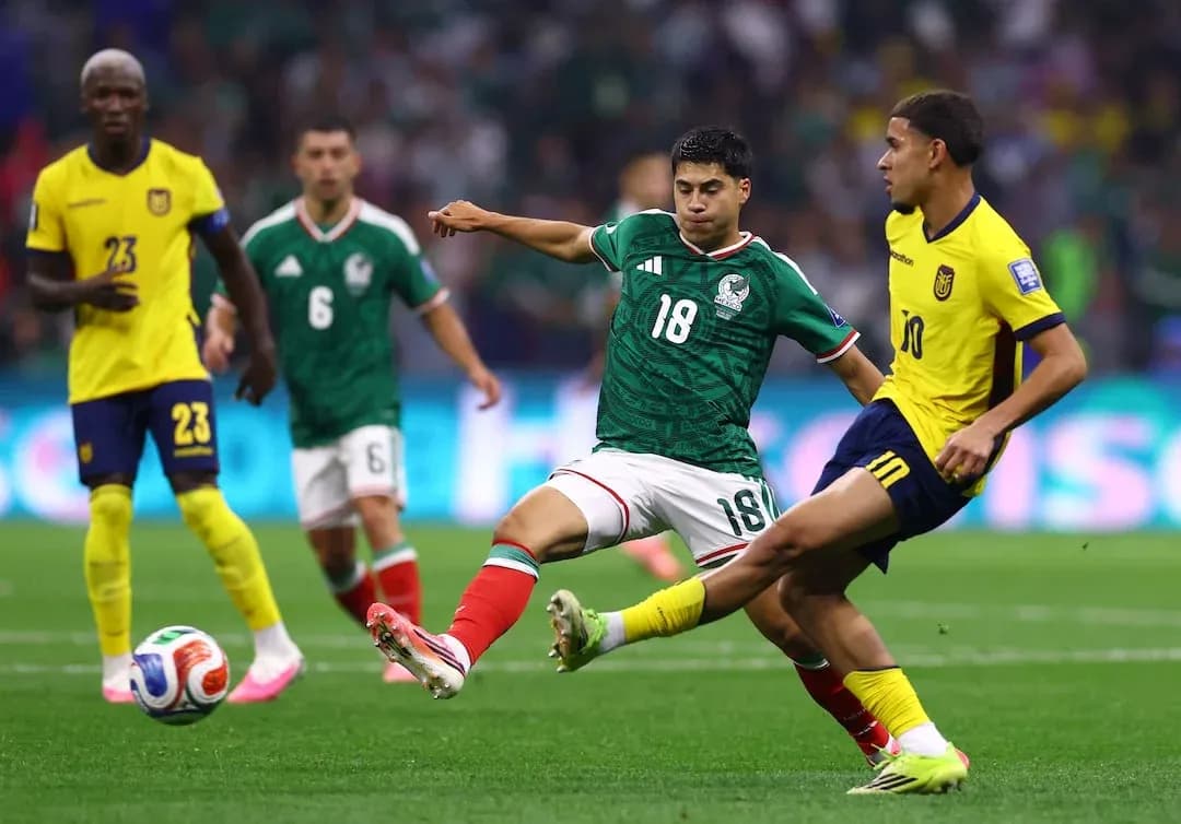 Mexico player tackling Ecuador player during match