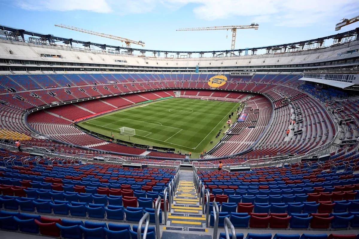 Empty stadium with green pitch and seating areas