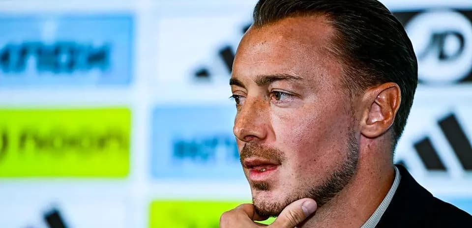 Player speaking at a press conference podium