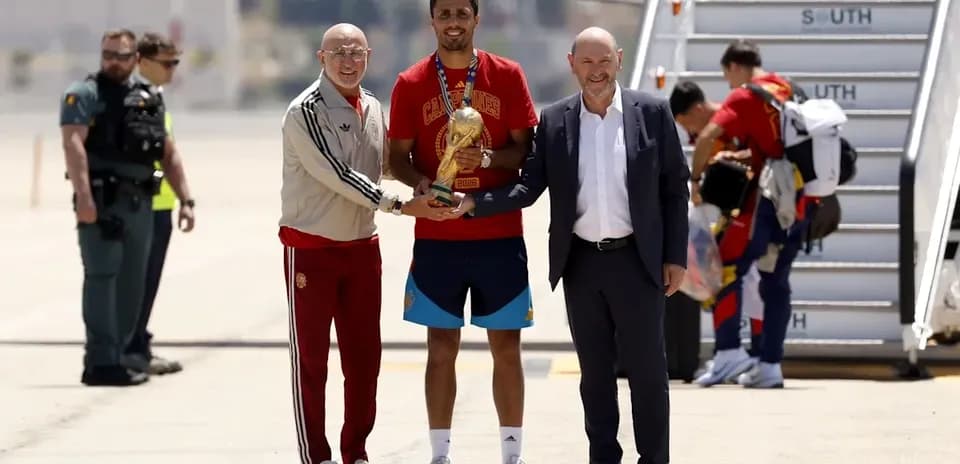 Player receiving trophy with officials at airport