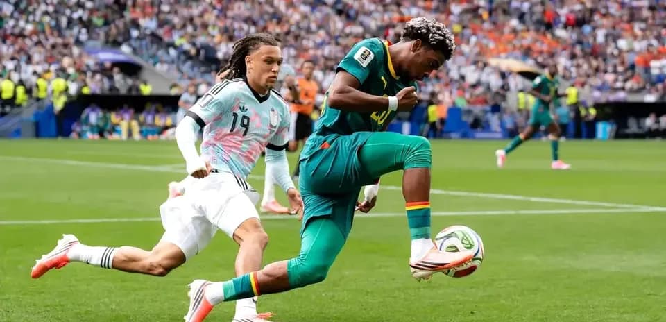 Player kicking ball while being chased by opponent