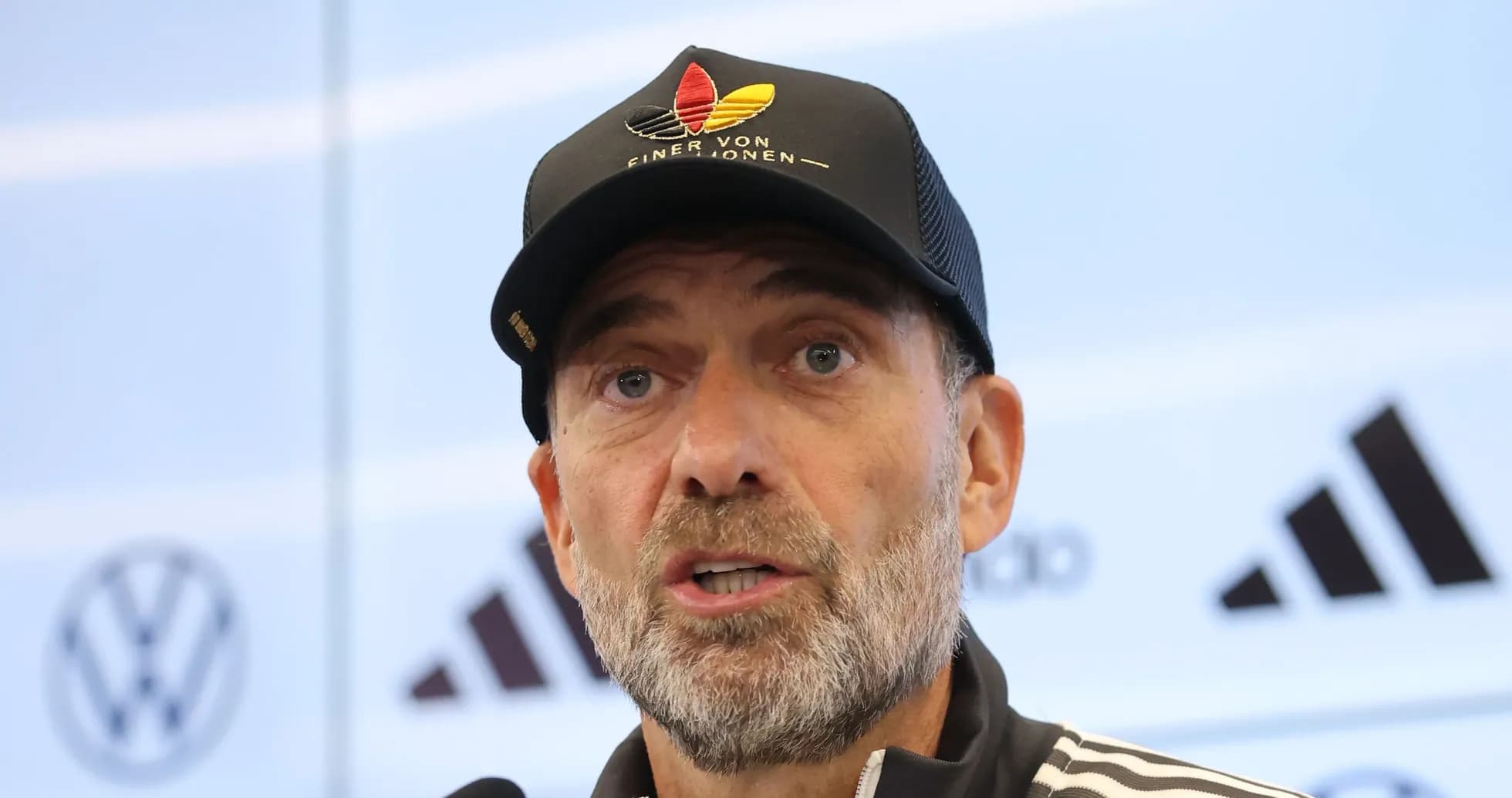 Manager speaking at press conference with branding backdrop