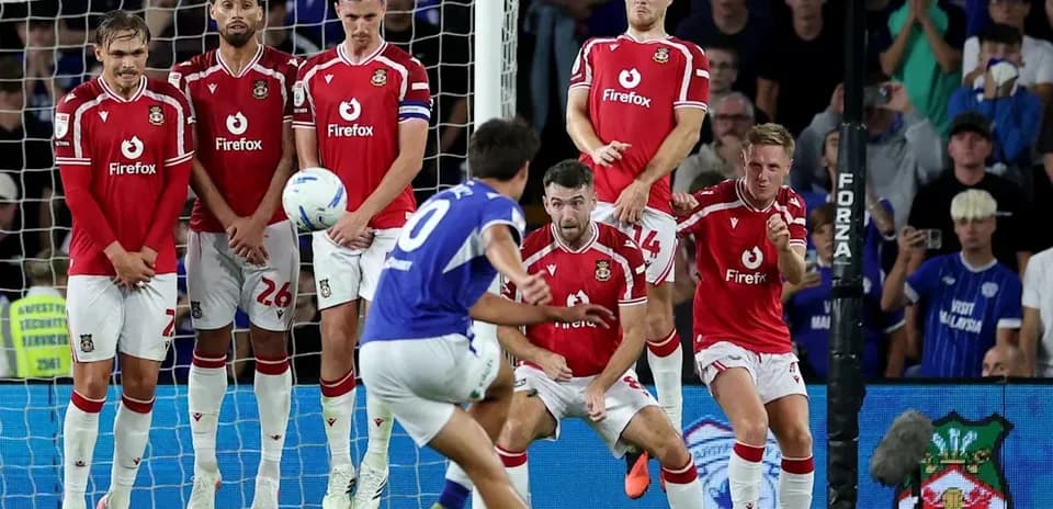 Player taking free kick as wall prepares to defend
