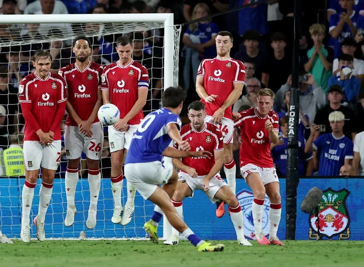 Player taking free kick as wall prepares to defend