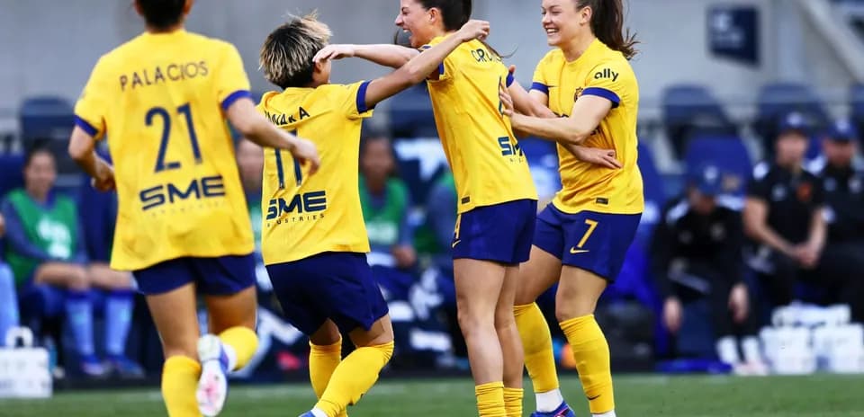 Players celebrating a goal during NWSL match