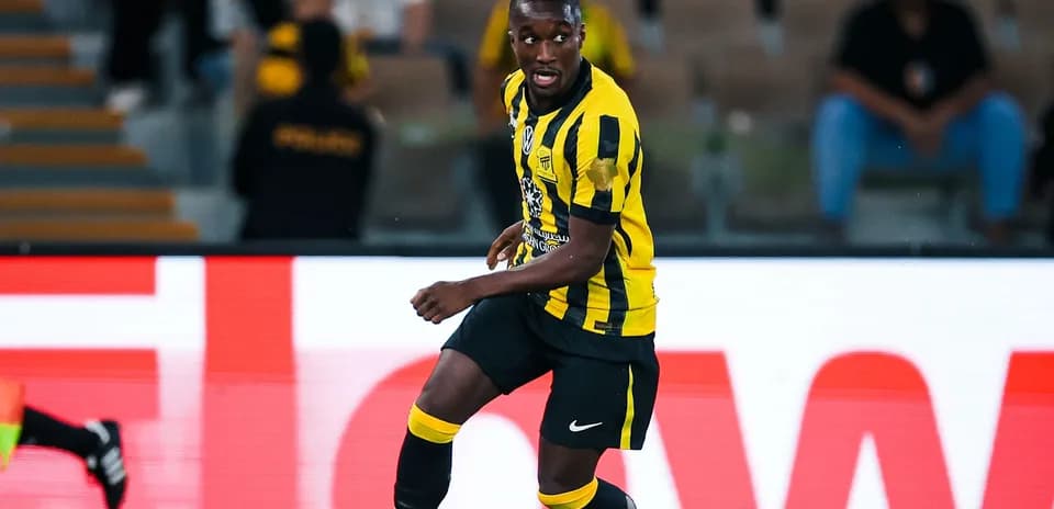 Player in yellow and black kit running with ball