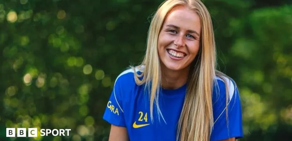 Female athlete smiling in blue sports jersey