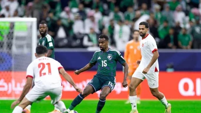 Saudi Arabian player dribbling past opponents during match