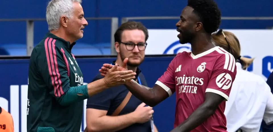 Coach and player shaking hands on the pitch