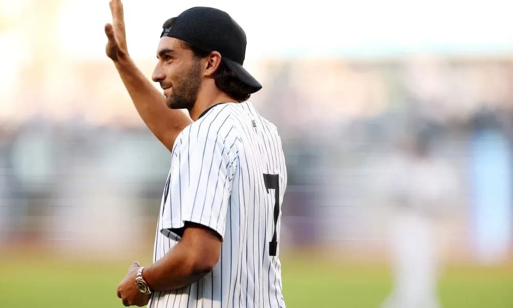 Man waving in Yankees jersey at baseball game