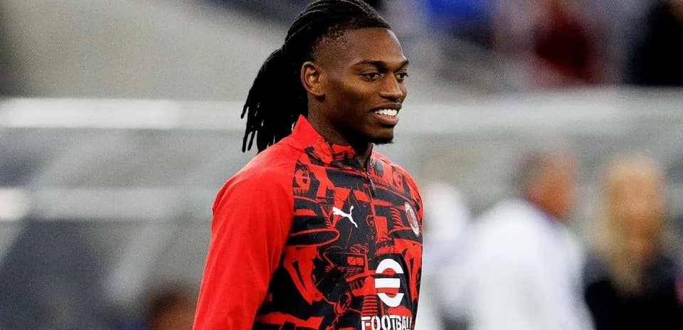 Player smiling in red training jacket before match