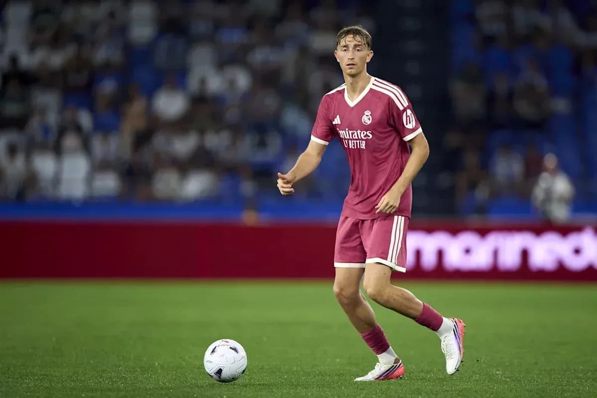 Player in pink kit dribbling ball on field