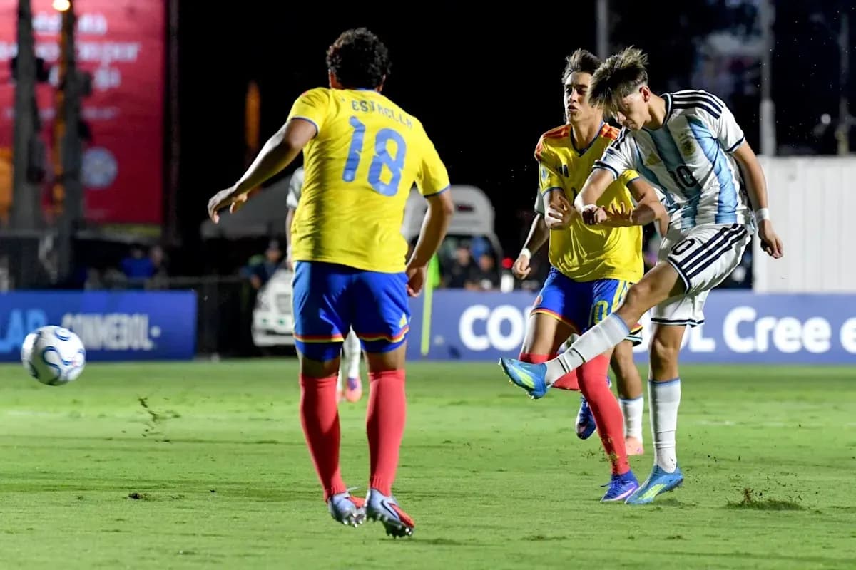 Argentinian player kicking ball against two defenders