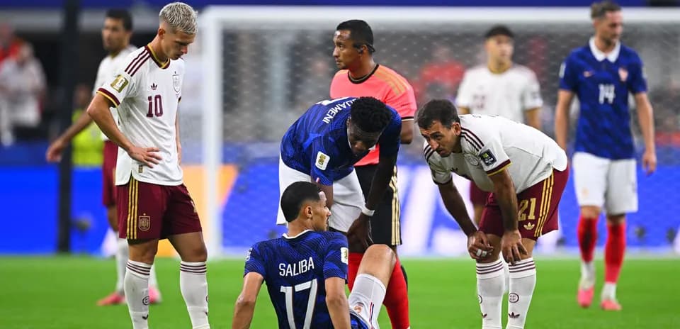Players attending to injured teammate during match