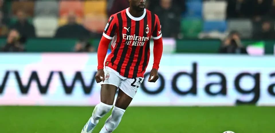 Player in AC Milan kit running with ball