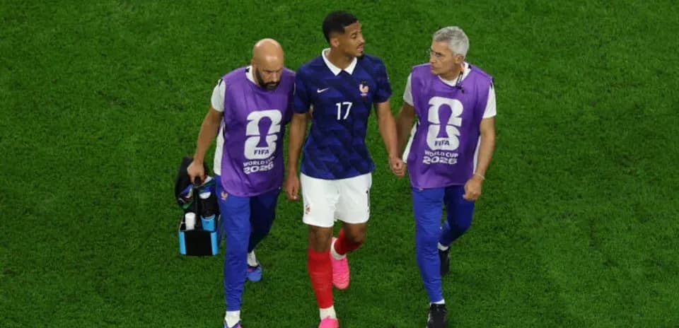 Player being assisted off the field by staff