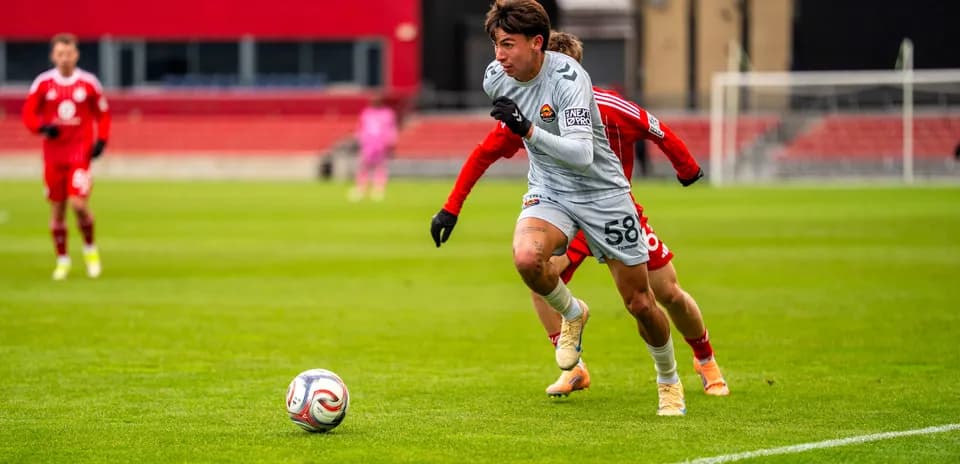 Player in gray chasing the ball on field