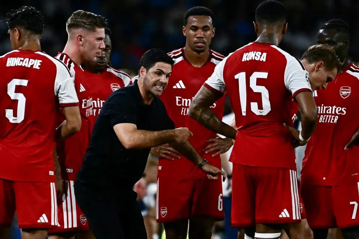 Arsenal players listening to coach during team huddle