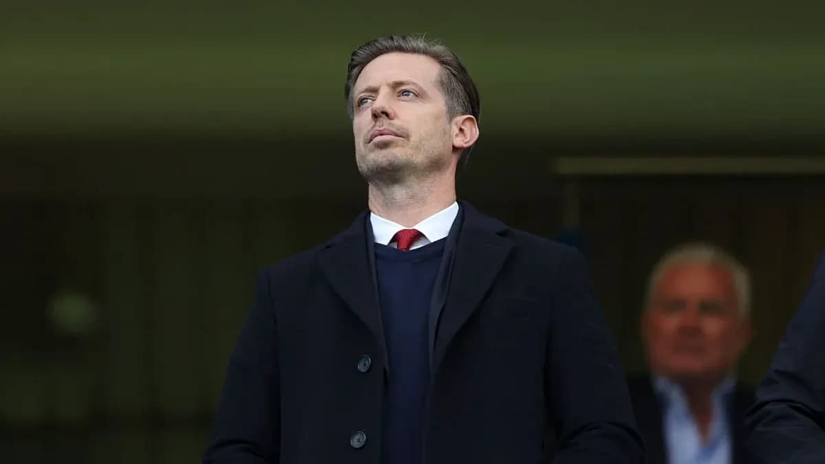 Man in suit observing from a stadium box
