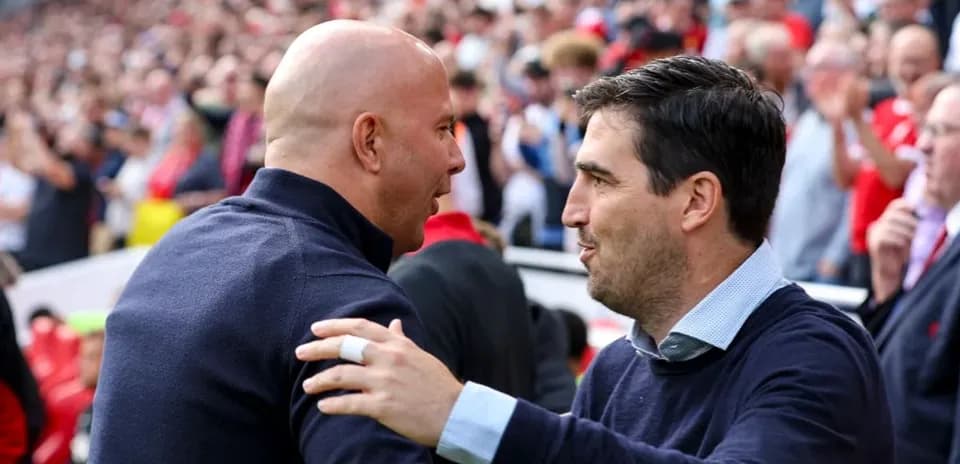 Two coaches greeting each other before the match