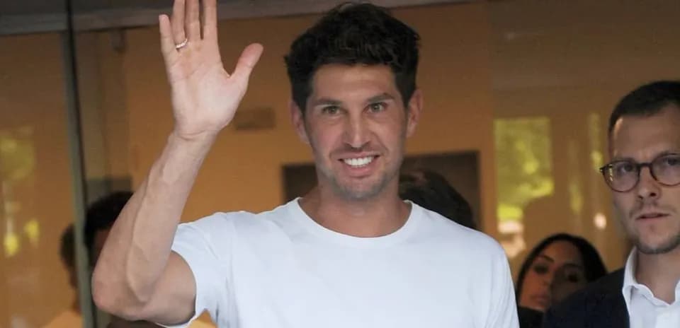 Man waving while standing next to another person