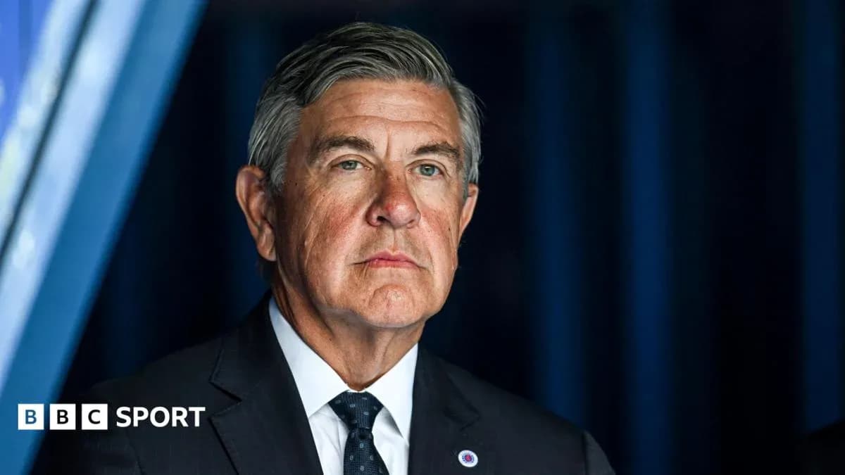 Man in a suit at a press conference backdrop