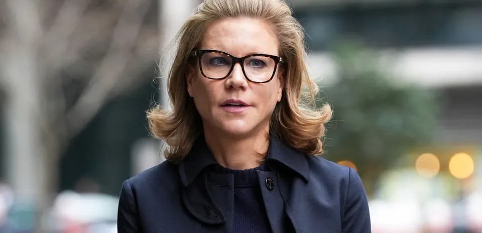 Woman with glasses walking outdoors in a coat