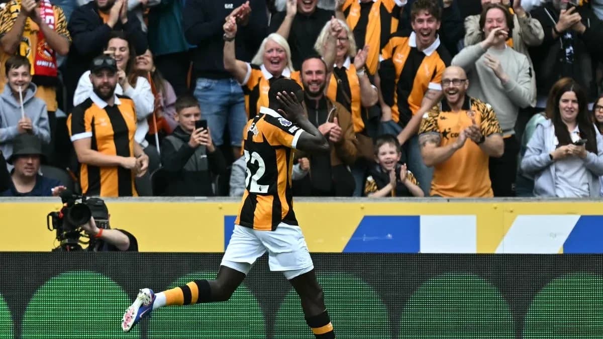 Player celebrating a goal with fans in stadium