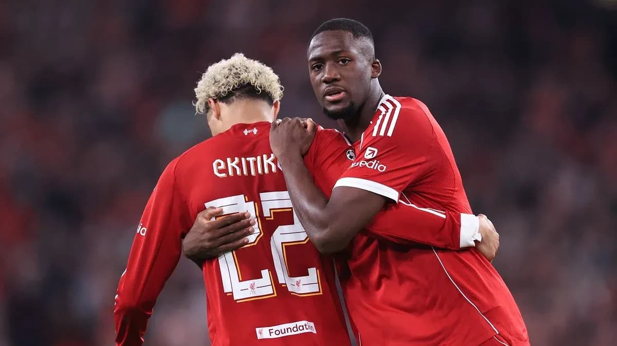 Two players in red jerseys embracing on field