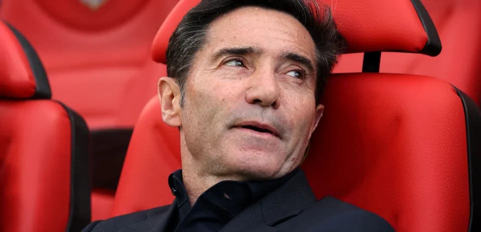 Coach seated on bench during a match