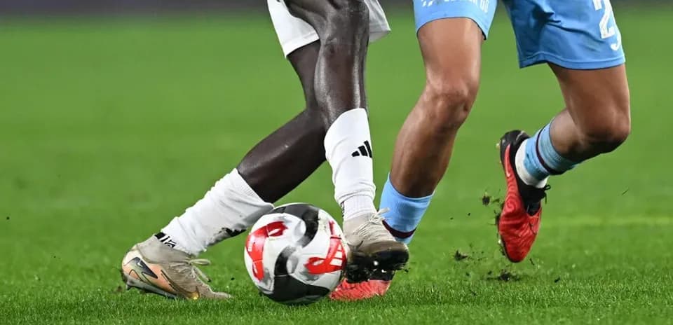 Two players battling for the ball on field