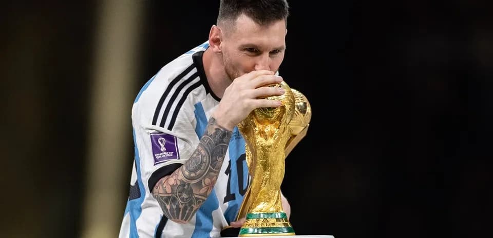 Player kissing FIFA World Cup trophy on stage