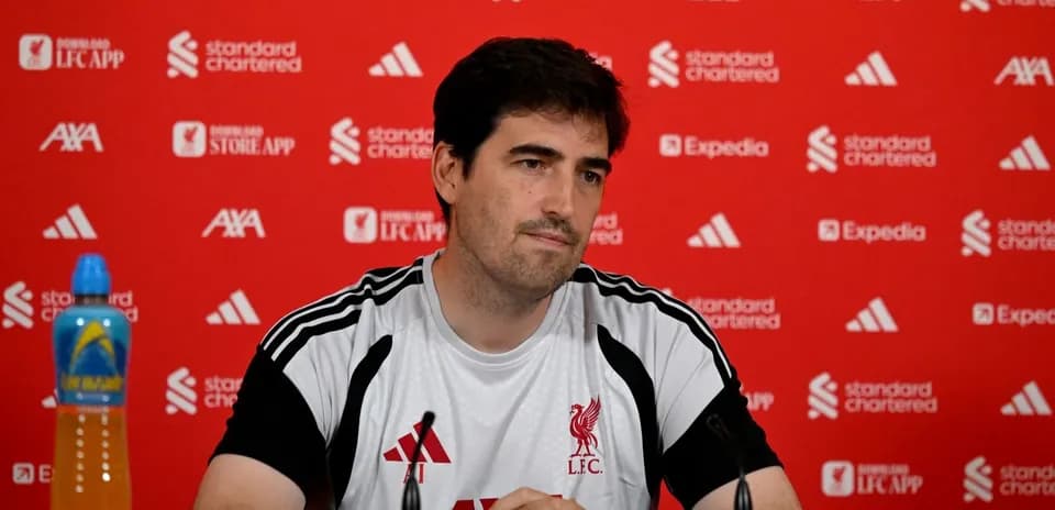 Manager at press conference with Liverpool branding