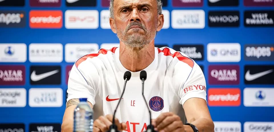 Manager at press conference with team logos backdrop