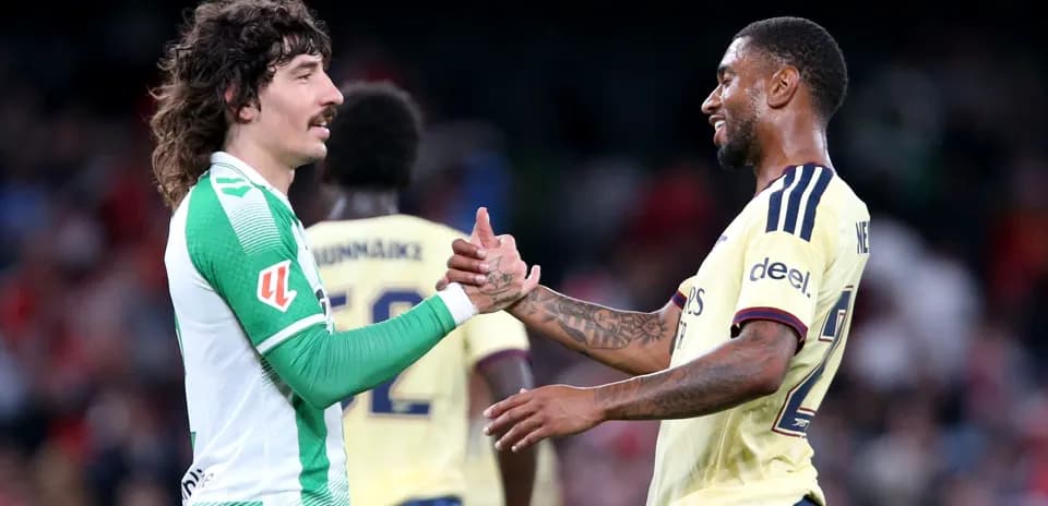 Two football players shaking hands on the field