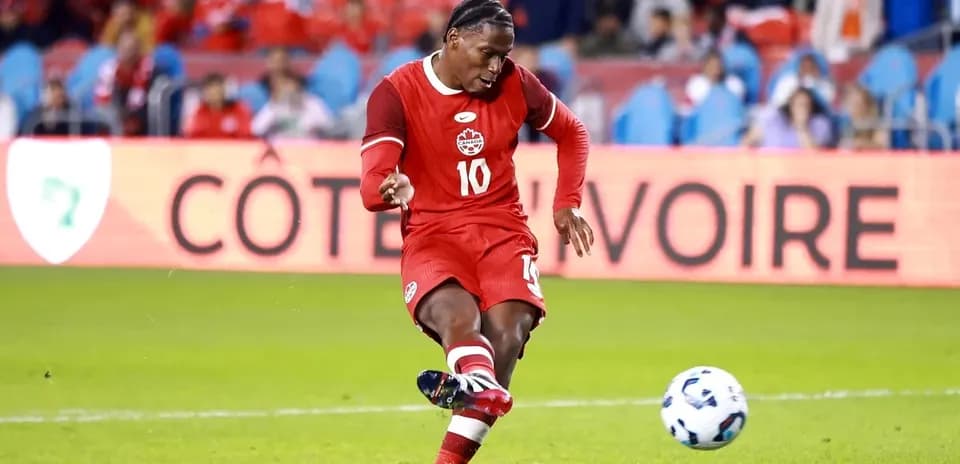 Player kicking a soccer ball in red uniform