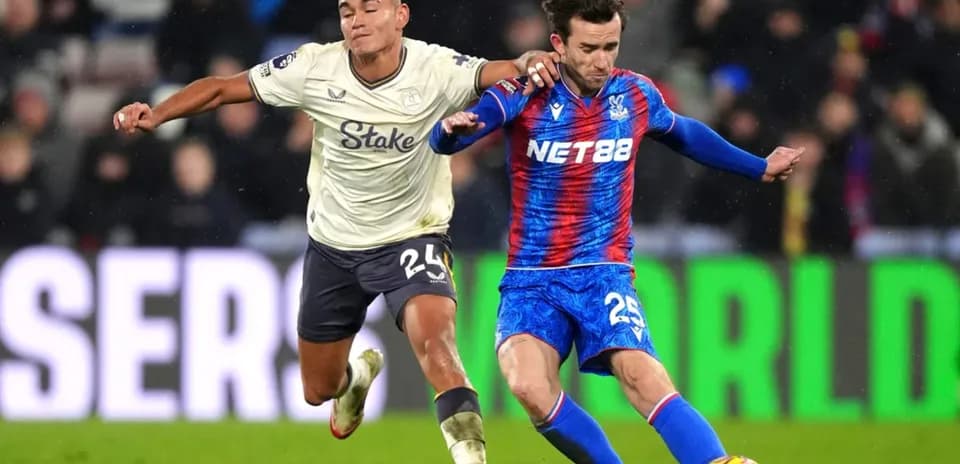 Crystal Palace player challenging Everton opponent