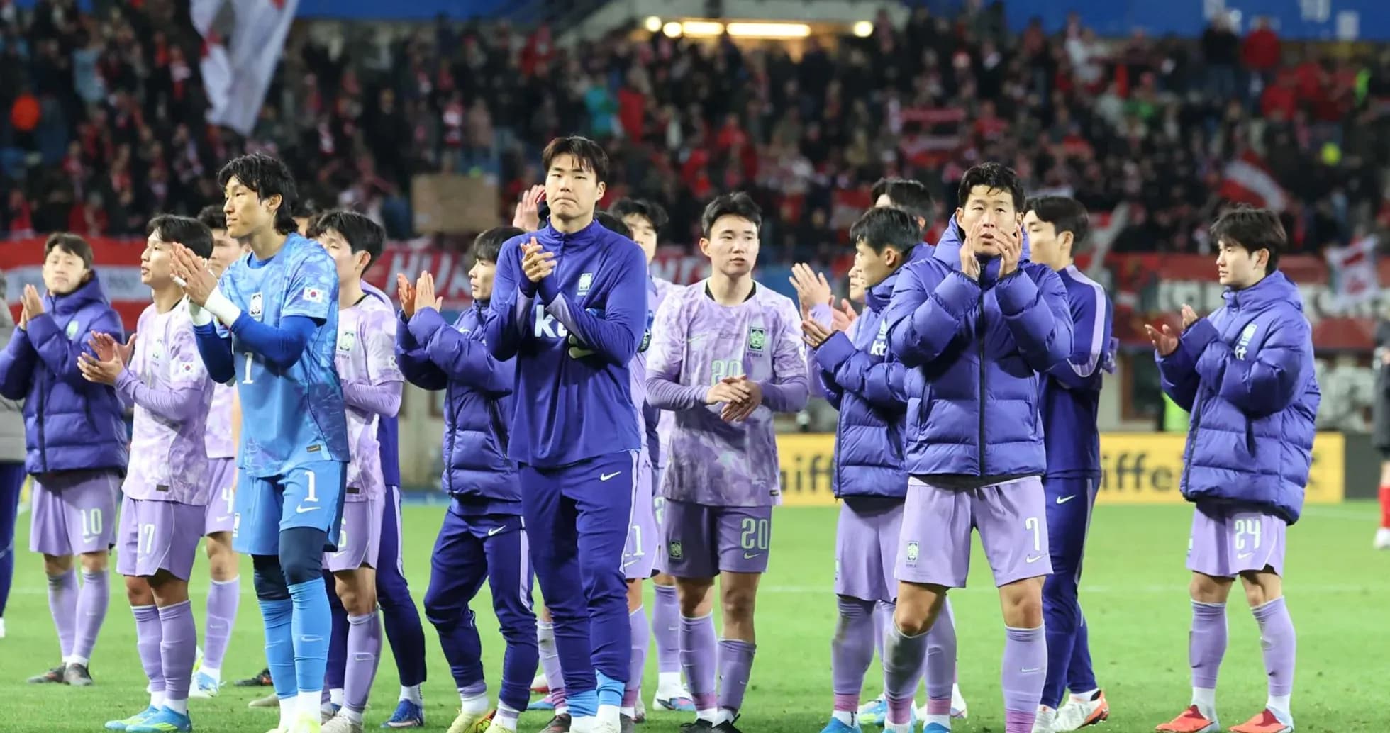 Team celebrating and applauding fans after match
