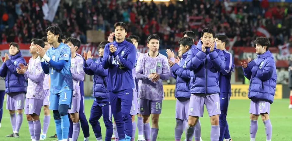Team celebrating and applauding fans after match