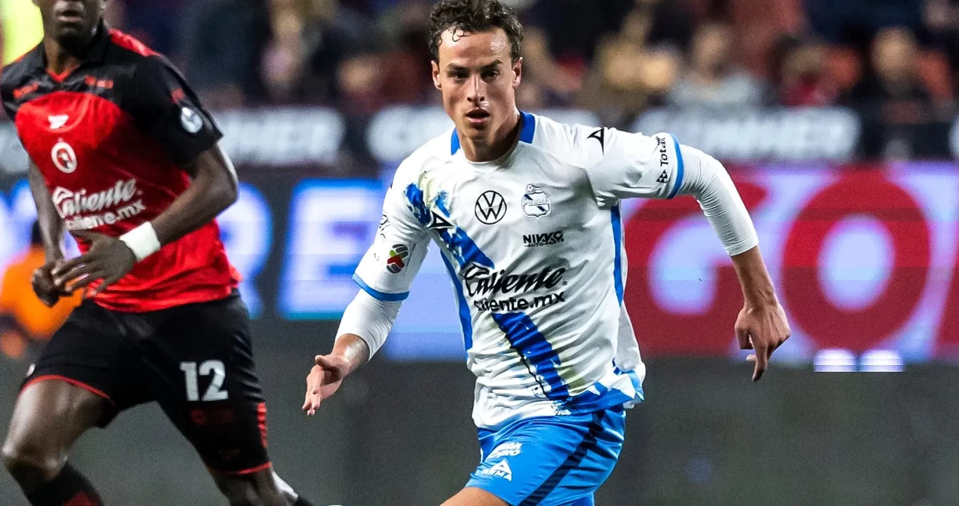 Puebla player dribbling against Club America opponent