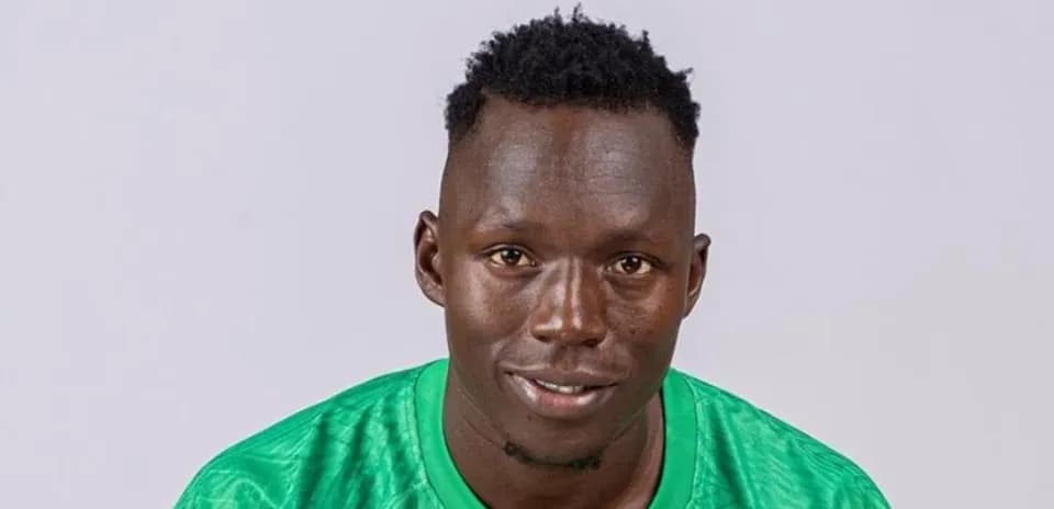 Football player wearing green jersey posing for photo