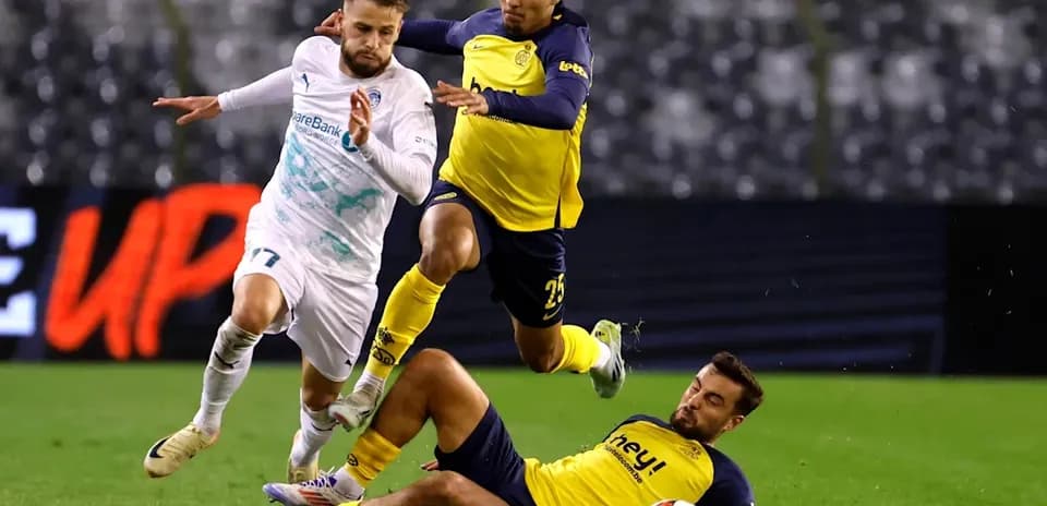 Three players involved in a tackle during match