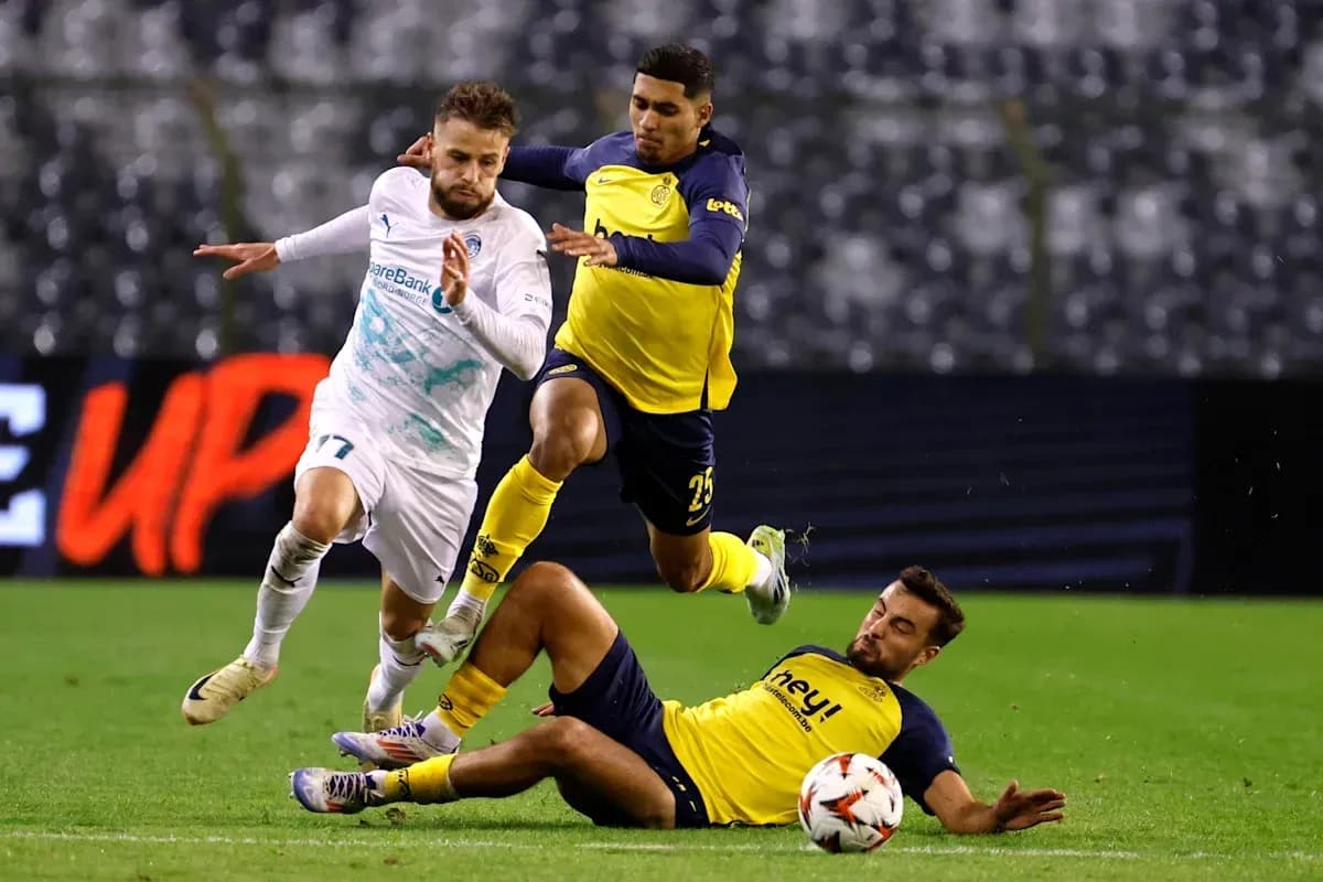 Three players involved in a tackle during match