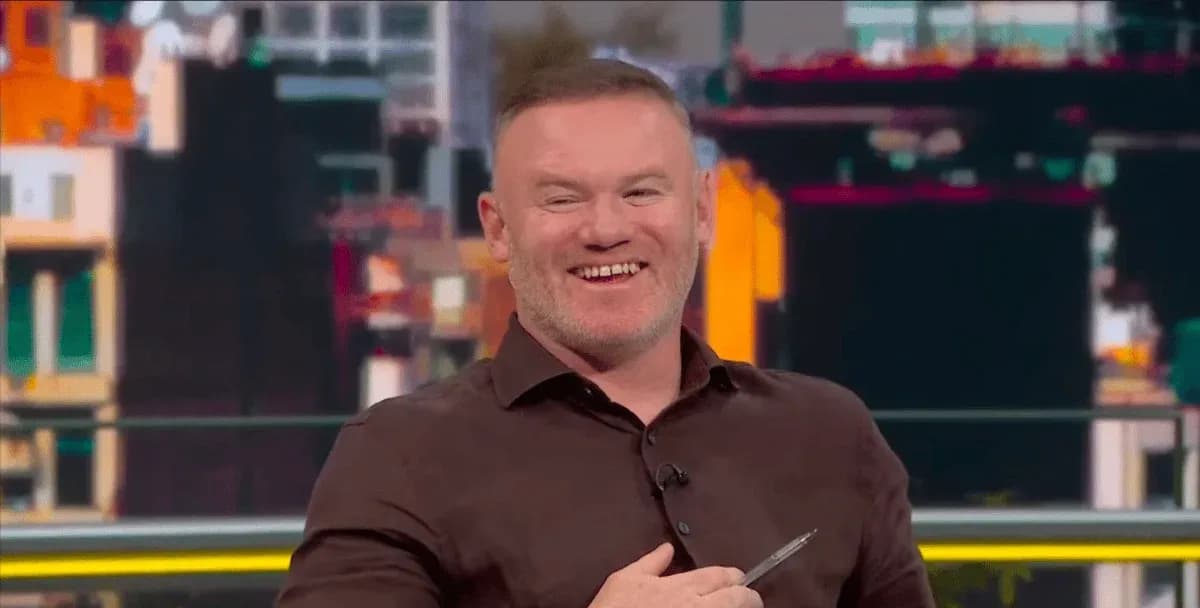 Presenter smiling while holding a pen on set